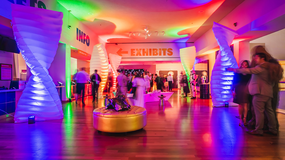 A decorated lobby with colorful lights and guests for a corporate holiday event.