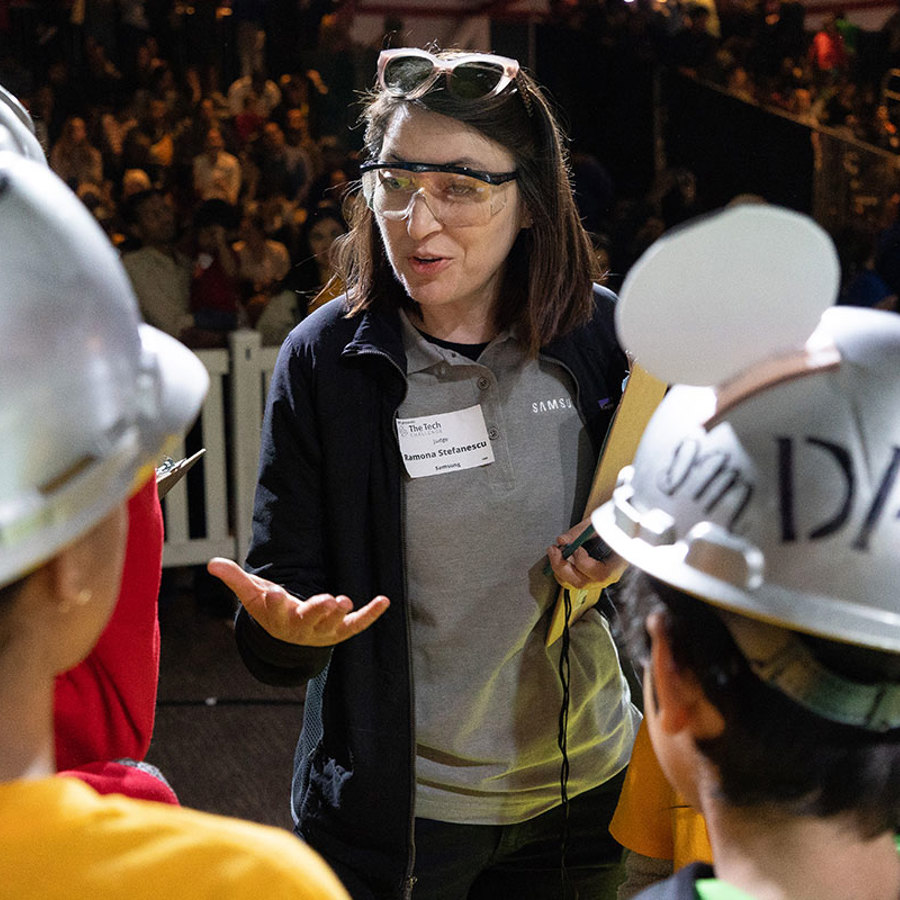 A corporate volunteer speaking to participants at The Tech Challenge.